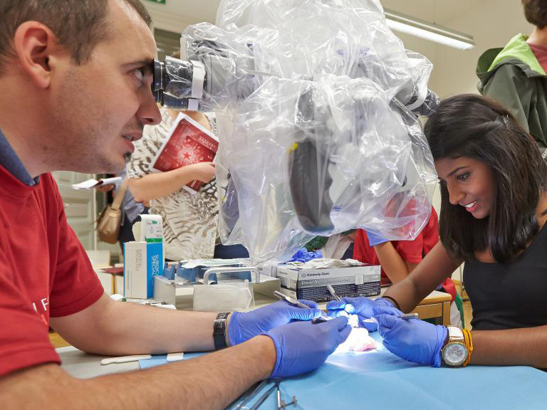 Junger Forschender schaut in ein Mikroskop.