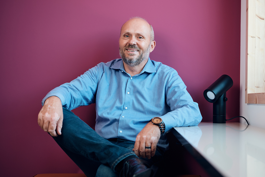 Ein Mann sitzt an einem Tisch mit einer kleinen Lampe.