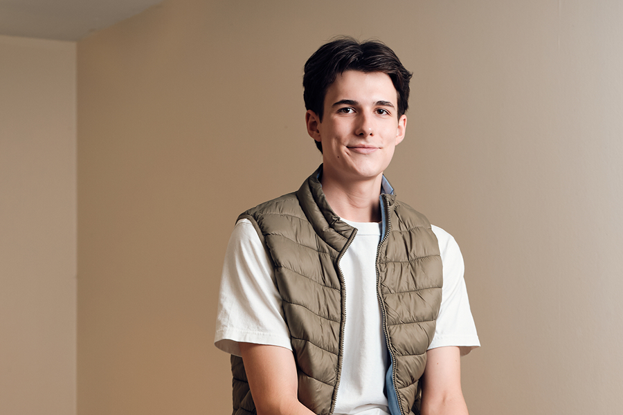 Ein junger Mann sitzt im Treppenhaus.